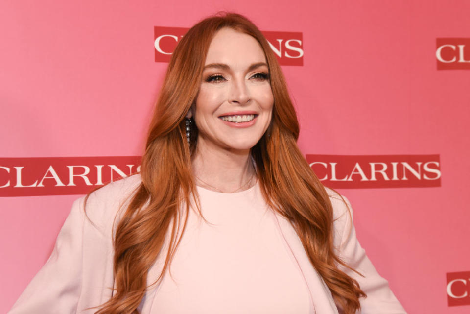 Woman in a high-necked blouse poses smiling at an event