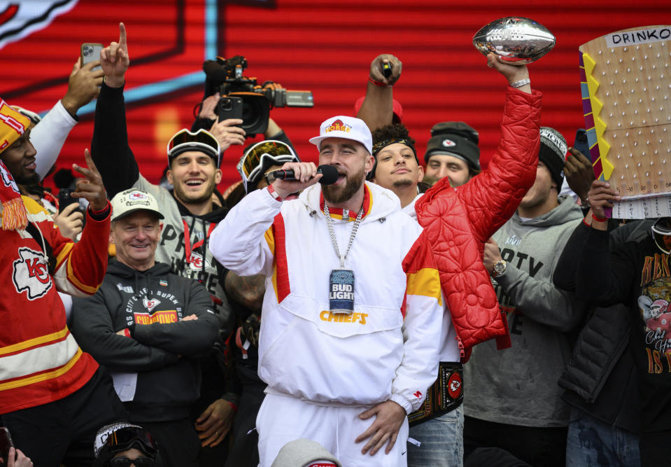 Kansas City Chiefs tight end Travis Kelce, center, is cheered on by Patrick Mahomes, back right, while giving a speech during the Chiefs' victory celebration and parade in Kansas City, Mo., Wednesday, Feb. 15, 2023. The Chiefs defeated the Philadelphia Eagles Sunday in the NFL Super Bowl 57 football game. (AP Photo/Reed Hoffmann)