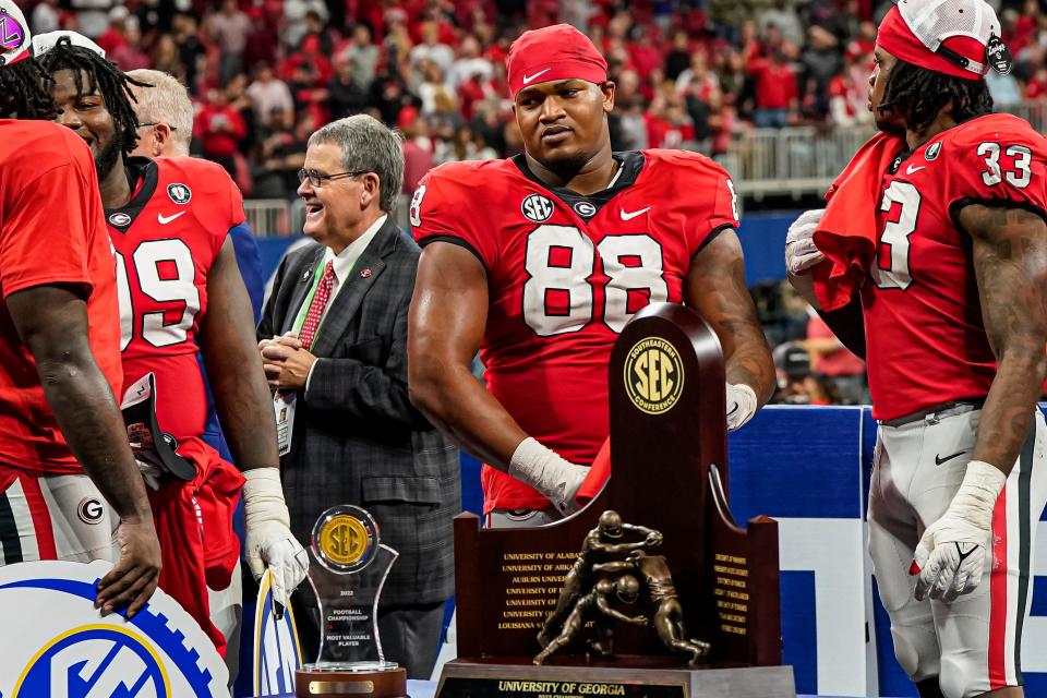 Georgia Bulldogs defensive lineman Jalen Carter (88) shown with the winning trophy after Georgia defeated the LSU Tigers in the SEC Championship game at Mercedes-Benz Stadium.