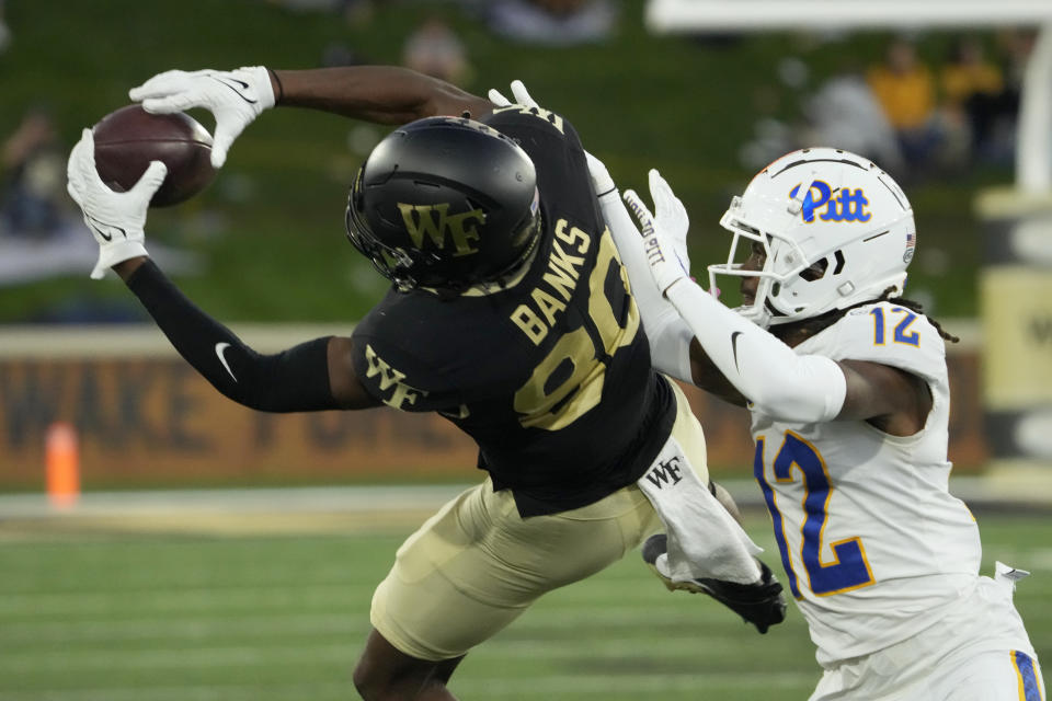 Wake Forest wide receiver Jahmal Banks (80) catches a pass against Pittsburgh defensive back M.J. Devonshire (12) during the second half of an NCAA college football game in Winston-Salem, N.C., Saturday, Oct. 21, 2023. (AP Photo/Chuck Burton)