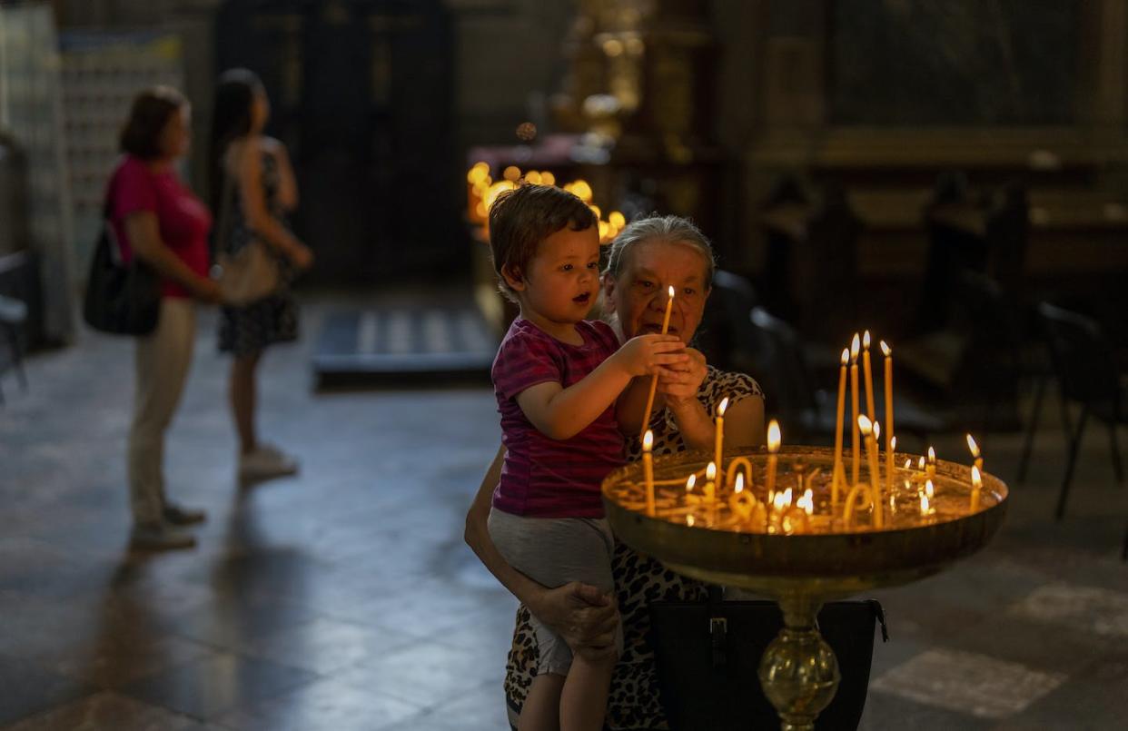 As the war continues in Ukraine, a grandmother helps her grandchild light candles in a church in Lviv. <a href="https://newsroom.ap.org/detail/RussiaUkraineWar/7c62ace9ac914c7eb47bb07244085fad/photo?Query=ukraine%20war%20&mediaType=photo&sortBy=&dateRange=Anytime&totalCount=27912&currentItemNo=359" rel="nofollow noopener" target="_blank" data-ylk="slk:AP Photo/Emilio Morenatti;elm:context_link;itc:0;sec:content-canvas" class="link ">AP Photo/Emilio Morenatti</a>