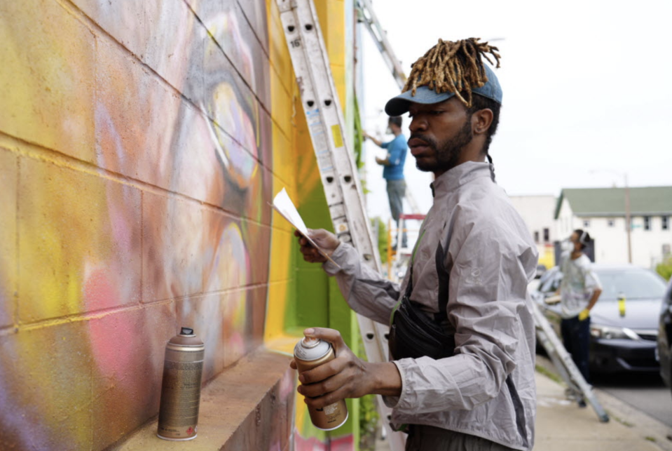 Artist and activist Tyrone Randle of Milwaukee works on the mural.