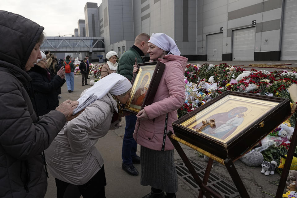 Orthodox believers attend a service at a makeshift memorial in front of the Crocus City Hall on the western outskirts of Moscow, Russia, Tuesday, March 26, 2024. Russian state news agency Tass says 22 victims of the concert hall attack that killed more than 130 people remain in serious condition in the hospital. (AP Photo/Alexander Zemlianichenko)