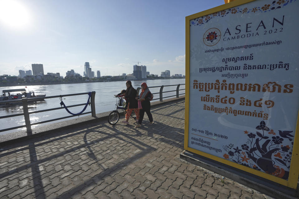 FILE - Muslim villagers walk alongside the Tonle Sap river past an Association of Southeast Asian Nations (ASEAN) poster advertising the upcoming summits in Phnom Penh, Cambodia, Nov. 7, 2022. Southeast Asian leaders convene in the Cambodian capital Thursday, faced with the challenge of trying to curtail escalating violence in Myanmar while the country’s military-led government shows no signs of complying with the group’s peace plan. (AP Photo/Heng Sinith, File)