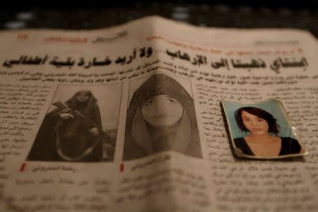 Photographs of Rahma (L and passport photo), the wife of Noureddine Chouchane, who was killed during a U.S. air strike in Libya, and her sister Ghofran (R, on newspaper), are seen in Tunis, Tunisia April 14, 2016. REUTERS/Zohra Bensemra/File Photo