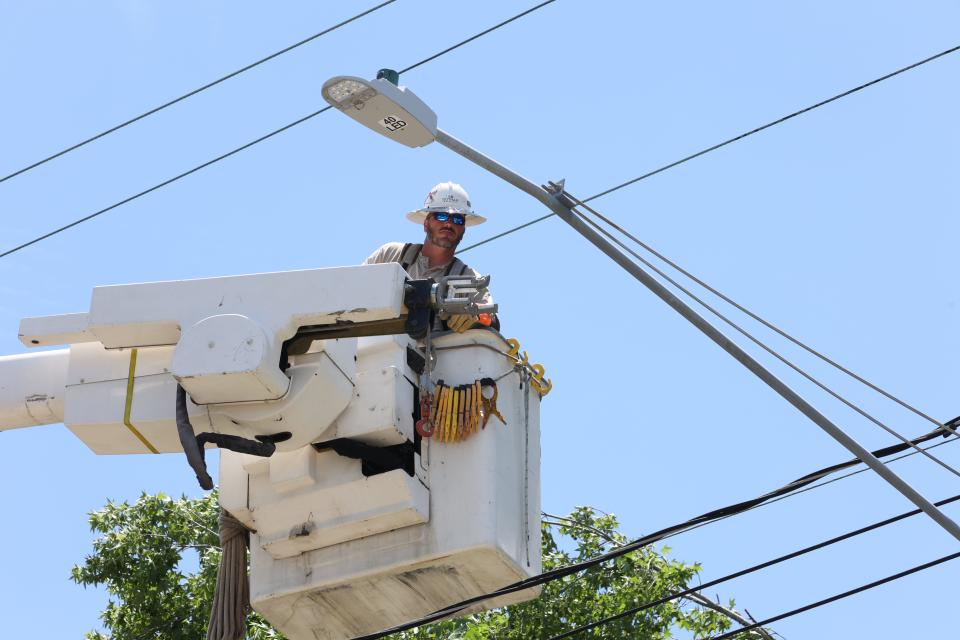 Lineman Jacob Willaimson, who works with a crew from Dothan, Alabama, repairs a utility pole on Stuckey Avenue on Saturday afternoon.