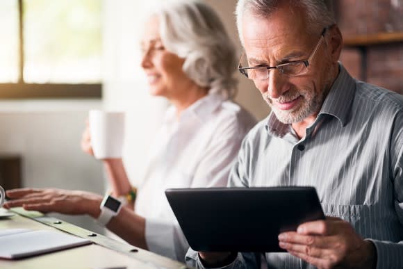 Grey haired couple looking at things.