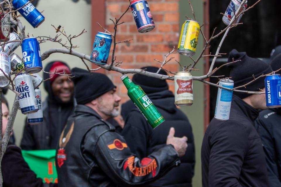 Beer cans hang from a tree during the St. Patrick's Parade along Michigan Avenue in Detroit's Corktown on Sunday, March 13, 2022.