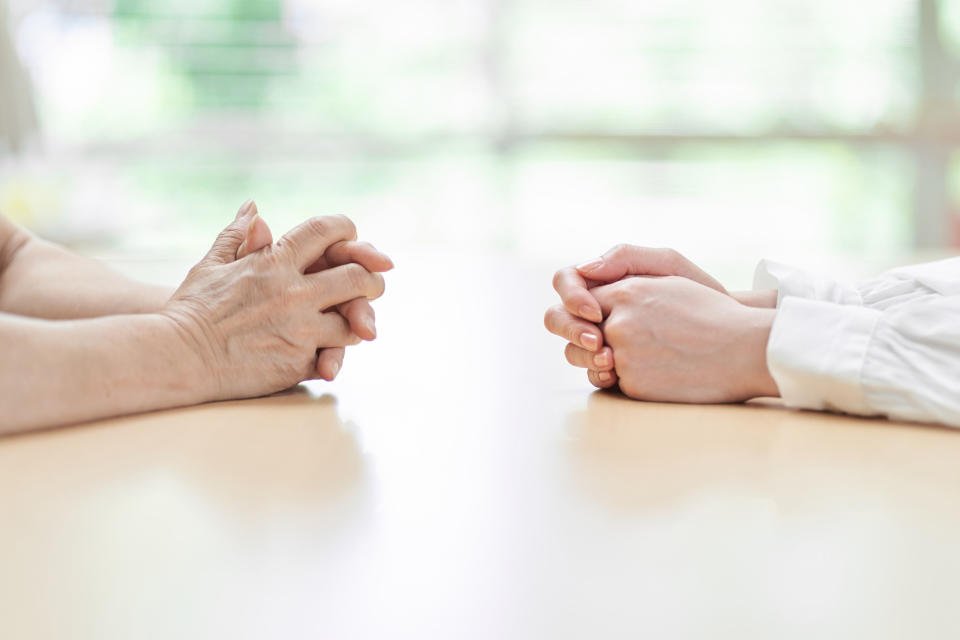 Two hands folded on a table