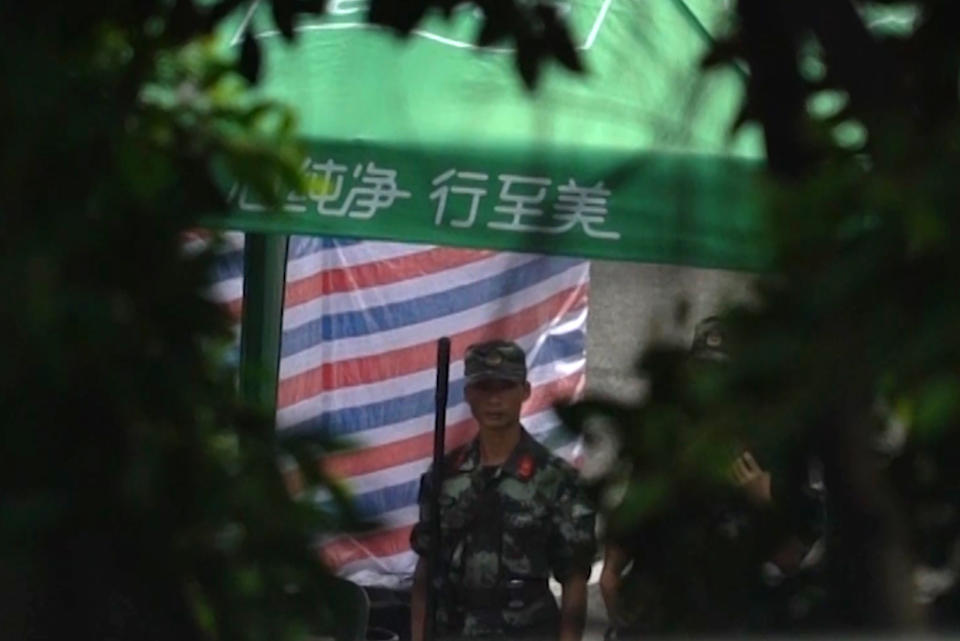 In this image made from video, a soldier stands guard near armed police vehicles parked outside Shenzhen Bay Stadium in Shenzhen, near Hong Kong, Friday, Aug. 16, 2019. Satellite photos show what appear to be armored personnel carriers and other vehicles belonging to the China's paramilitary People's Armed Police parked in a sports complex in the city of Shenzhen, in what some have interpreted as a threat from Beijing to use increased force against pro-democracy protesters across the border in Hong Kong.(AP Photo/Dake Kang)