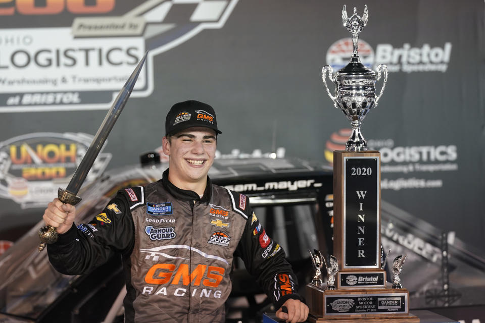 Sam Mayer poses with the sword and trophy as he celebrates in Victory Lane after winning the NASCAR Truck Series auto race, Thursday Sept. 17, 2020, in Bristol, Tenn. (AP Photo/Steve Helber)