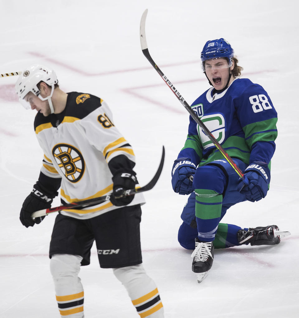 Vancouver Canucks' Adam Gaudette, right, celebrates after scoring a goal, as Boston Bruins' Anton Blidh, of Sweden, skates to the bench during the second period of an NHL hockey game Saturday, Feb. 22, 2020, in Vancouver, British Columbia. (Darryl Dyck/The Canadian Press via AP)
