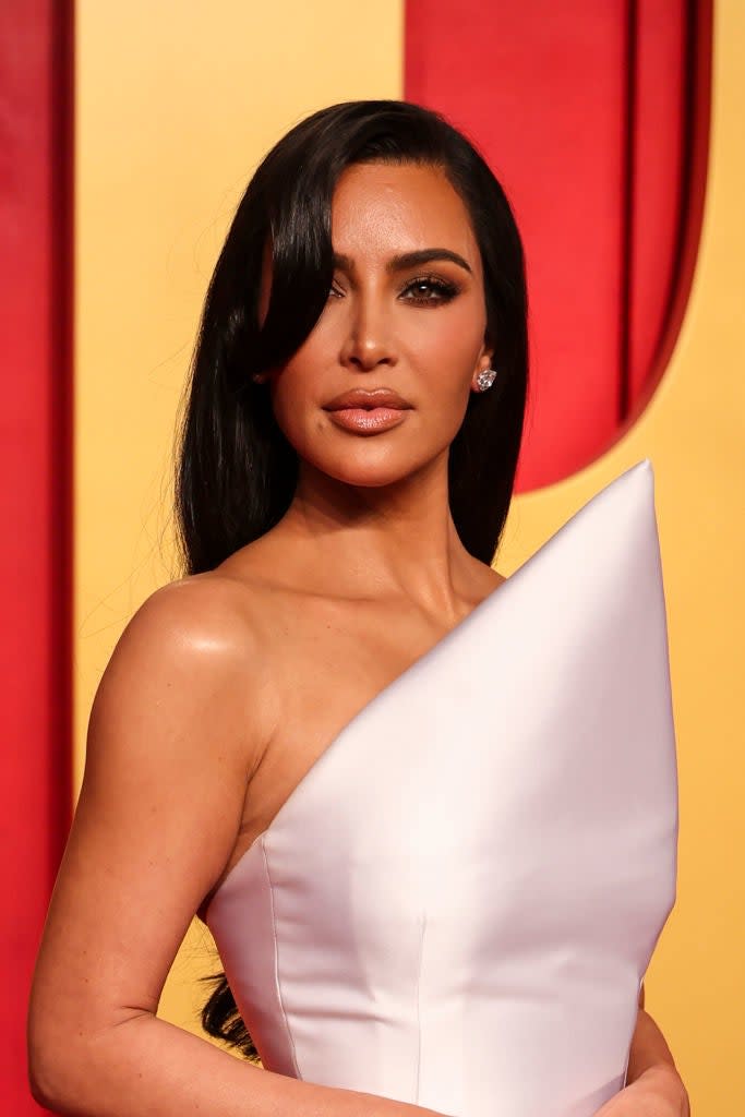 Kim Kardashian in a strapless dress with a high pointed bodice on the red carpet