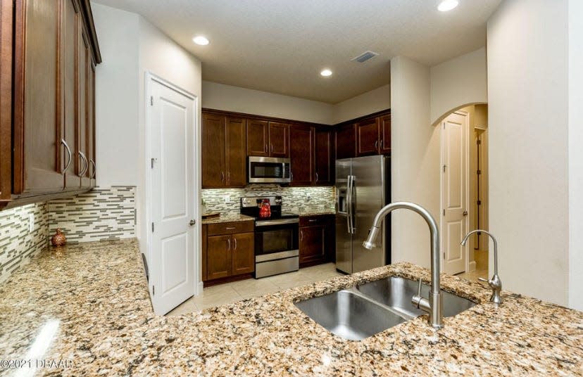 The beautiful and open kitchen is equipped with top-of-the-line Maytag appliances, tile backsplash and granite countertops.