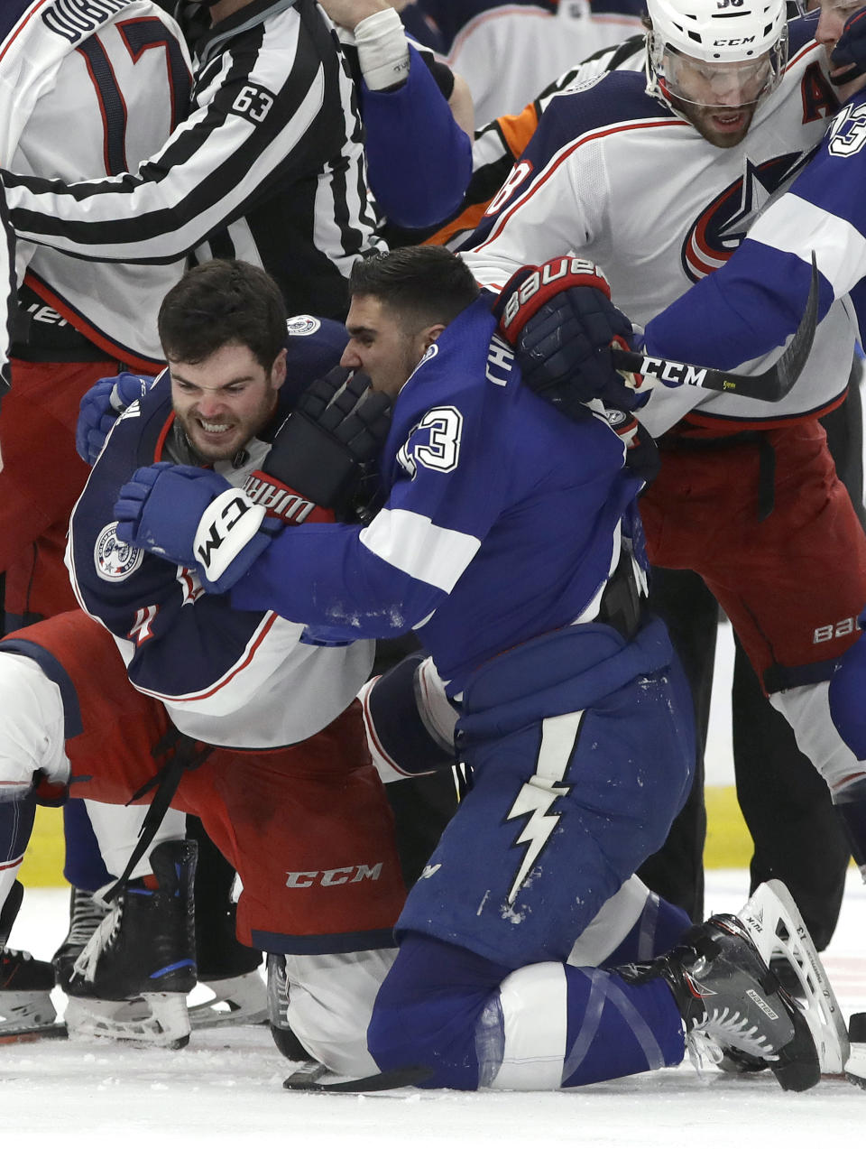 Tampa Bay Lightning center Cedric Paquette (13) and Columbus Blue Jackets defenseman Scott Harrington (4) scrap during the first period of Game 1 of an NHL Eastern Conference first-round hockey playoff series Wednesday, April 10, 2019, in Tampa, Fla. (AP Photo/Chris O'Meara)