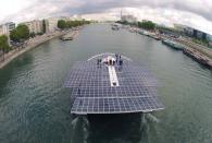 The Turanor PlanetSolar, the world's largest solar-powered boat, travels on the Seine river next to the Eiffel tower in Paris September 10, 2013. PlanetSolar, a catamaran powered exclusively by solar energy, completed the first solar-powered trip around the world on May 4, 2012 after traveling over 60,000 km (37,282 miles) in 584 days. (REUTERS/Charles Platiau)