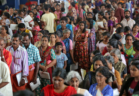 Flood-affected people wait to receive food inside a college auditorium, which has been converted into a temporary relief camp, in Kochi in the southern state of Kerala, India, August 20, 2018. REUTERS/Sivaram V