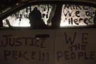 A protester takes refuge from snowfall while sitting outside the Ferguson Police Station in Missouri November 26, 2014. REUTERS/Adrees Latif