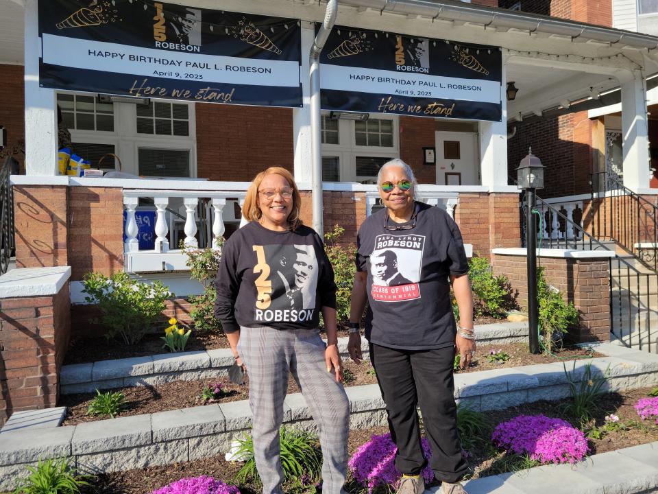 Paul Robeson House Executive Director Janice Sykes-Ross, left, and former Executive Director Vernoca Michael, stand in front of the Paul Robeson House and Museum during the 125th birthday festivities for actor and activist Paul Robeson.