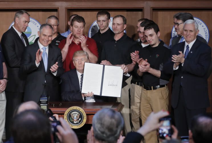 President Trump, seated, accompanied by coal miners and, from left, Interior Secretary Ryan Zinke, Environmental Protection Agency (EPA) Administrator Scott Pruitt, second from right, Energy Secretary Rick Perry, and Vice President Mike Pence, far right, holds up the signed Energy Independence Executive Order on March 28, 2017, at EPA headquarters in Washington. (Photo: Pablo Martinez Monsivais/AP)