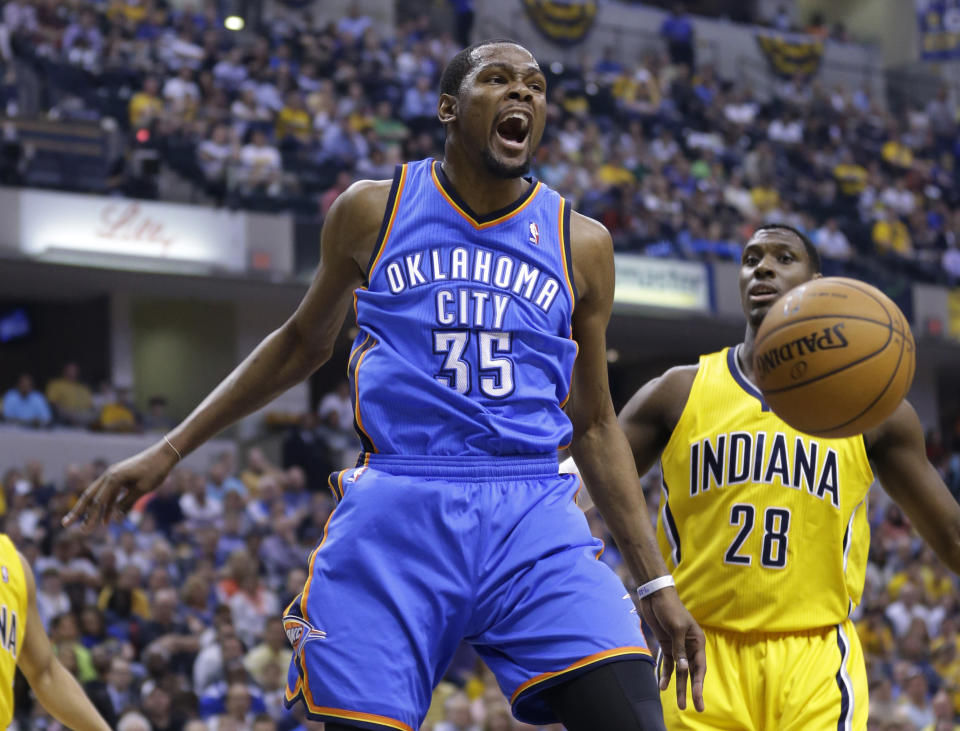 Oklahoma City Thunder forward Kevin Durant reacts after a dunk in front of Indiana Pacers center Ian Mahinmi in the first half of an NBA basketball game in Indianapolis, Sunday, April 13, 2014. (AP Photo/Michael Conroy)