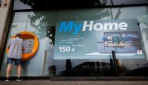 A man uses an ATM of a Caixabank office in Montgat