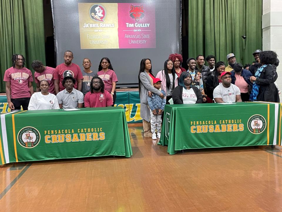 Pensacola Catholic defensive back Ja'Bril Rawls (left table, seated center) and defensive lineman Tim Gulley (right table, seated right) signed their letters of intent to play college football during the Early Signing Period on Wednesday, Dec. 21, 2022 from the Pensacola Catholic High School gymnasium.