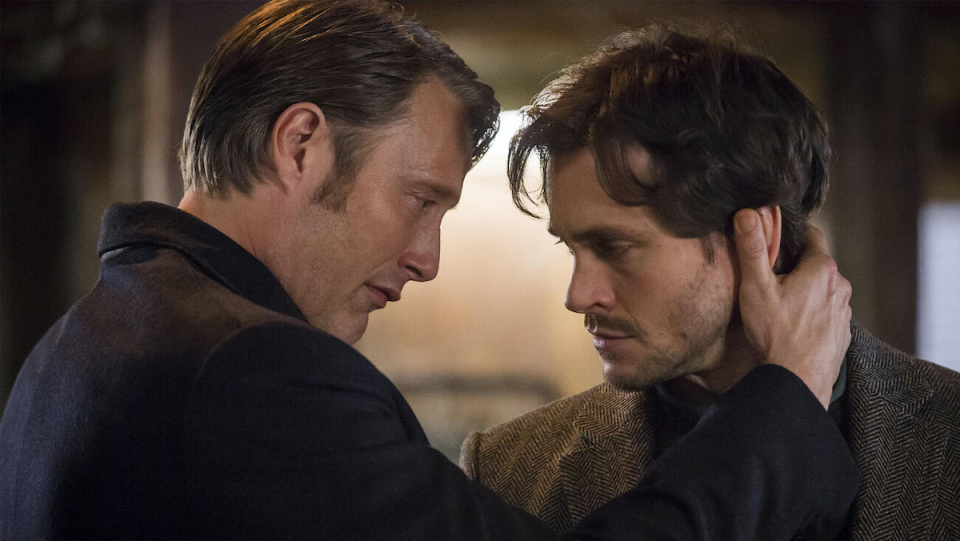 Hannibal holds Will's head in his hands.