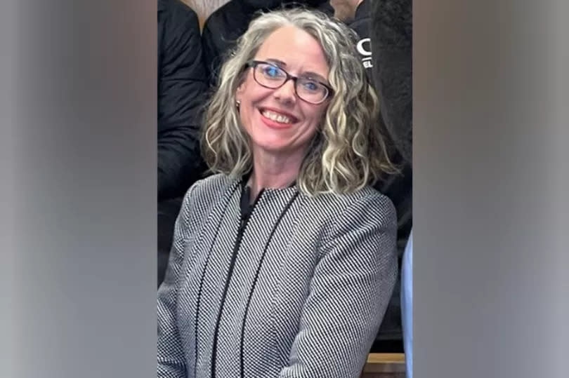 Sharon Kemp smiling at the camera wearing a black and white blazer