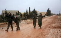 Syrian government soldiers celebrate after taking control of the village of Ratian, north of the embattled city of Aleppo, from rebel fighters on February 6, 2016