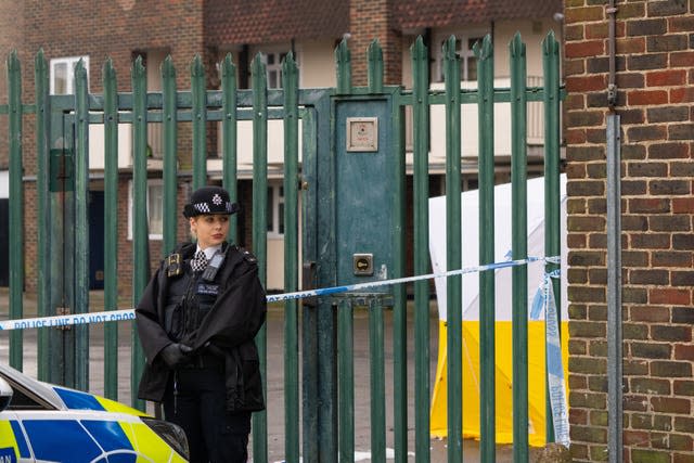 A police officer at the scene of a fatal stabbing at flats on Wisbeach Road in Croydon, London 