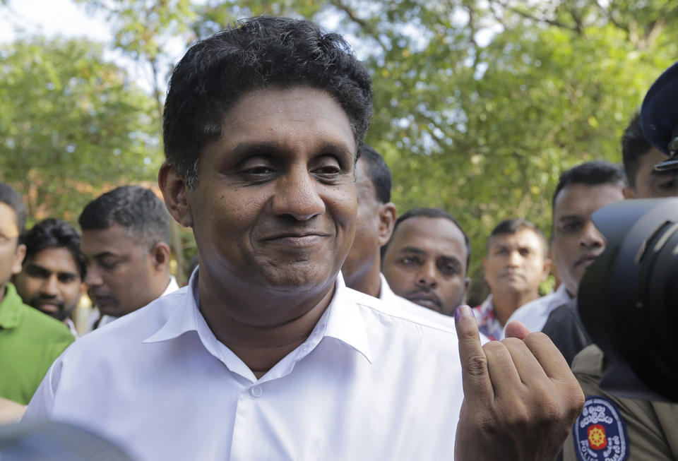 Presidential candidate of Sri Lanka's governing party Sajith Premadasa displays the indelible ink mark on his finger after casting his vote in Weerawila, Sri Lanka, Saturday, Nov. 16 , 2019. A convoy of buses carrying Muslim voters traveling in northern Sri Lanka was attacked by gunfire and stones, and blocked by burning tires, around midnight on Saturday hours before polls opened in Sri Lanka’s presidential election, according to Colombo-based Centre for Monitoring Election Violence. (AP Photo/Chamila Karunarathne )