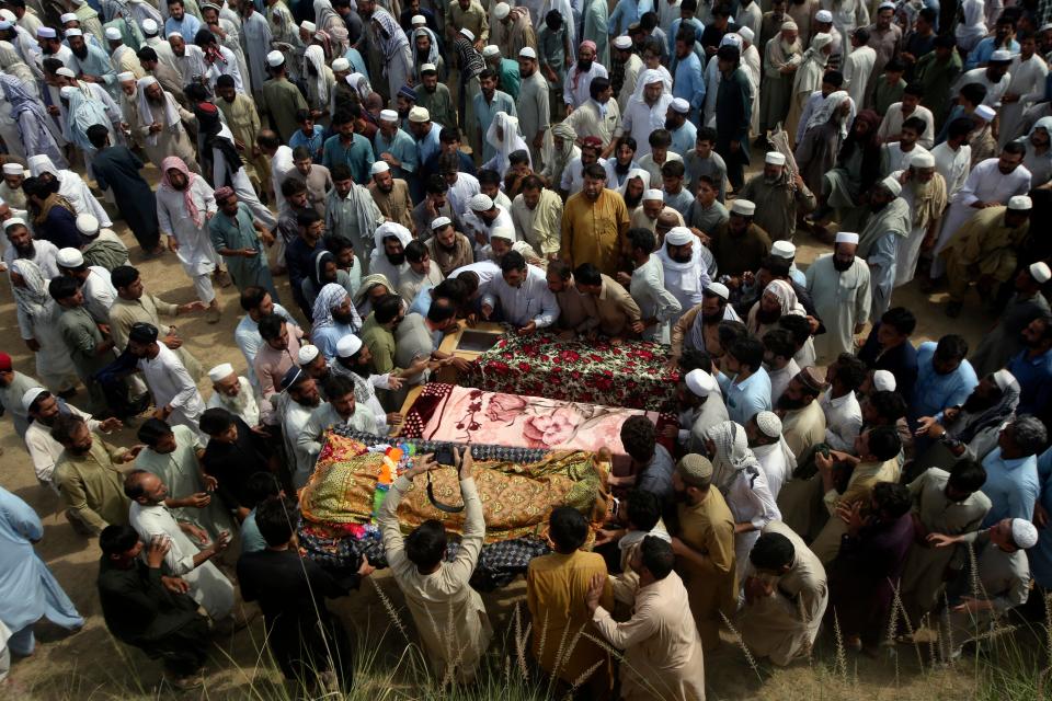Relatives and mourners gather around the caskets of victims who were killed in Sunday's suicide bomber attack in the Bajur district of Khyber Pakhtunkhwa, Pakistan, Monday, July 31, 2023.