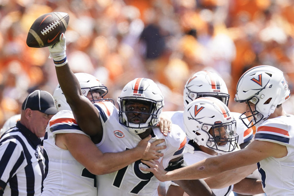 Virginia defensive tackle Olasunkonmi Agunloye (19) celebrates with teammates after making a fumble recovery against Tennessee in the first half of an NCAA college football game Saturday, Sept. 2, 2023, in Nashville, Tenn. (AP Photo/George Walker IV)