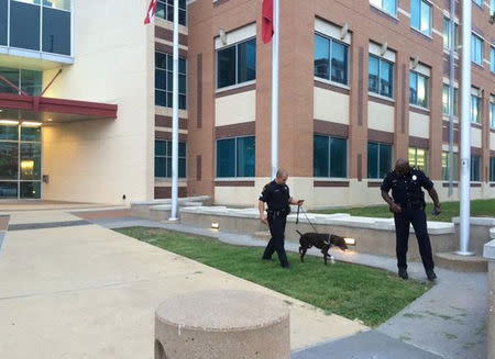 Police officers use a dog while searching for explosives outside the police headquarters in Dallas, Texas, in this handout photo released by the Dallas Police Department on June 13, 2015. REUTERS/Dallas Police Department/Handout via Reuters