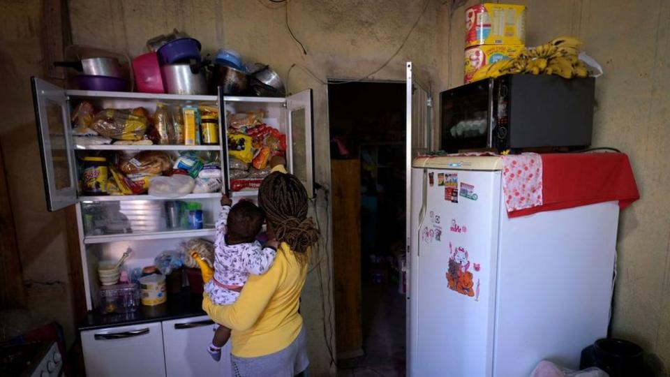 Celia Barros com filho no colo em Santa Luzia (MG); ela ligou para a polícia pedindo ajuda para a família conseguir comer. Percentual de famílias com crianças passando fome no Brasil praticamente dobrou entre 2020 e 2022