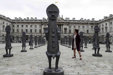 An assistant poses with the sculptures "Black and Blue: The invisible Man and the Masque of Blackness", by artist Zak Ove, at Somerset House in London, Britain October 4, 2016. REUTERS/Stefan Wermuth