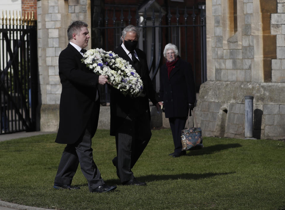 Andre and Stan Walker lay a floral wreath for Prince Philip outside Windsor Castle in Windsor, England, Friday, April 16, 2021. Prince Philip husband of Britain's Queen Elizabeth II died April 9, aged 99, his funeral will take place Saturday at Windsor Castle in St George's Chapel. (AP Photo/Alastair Grant)