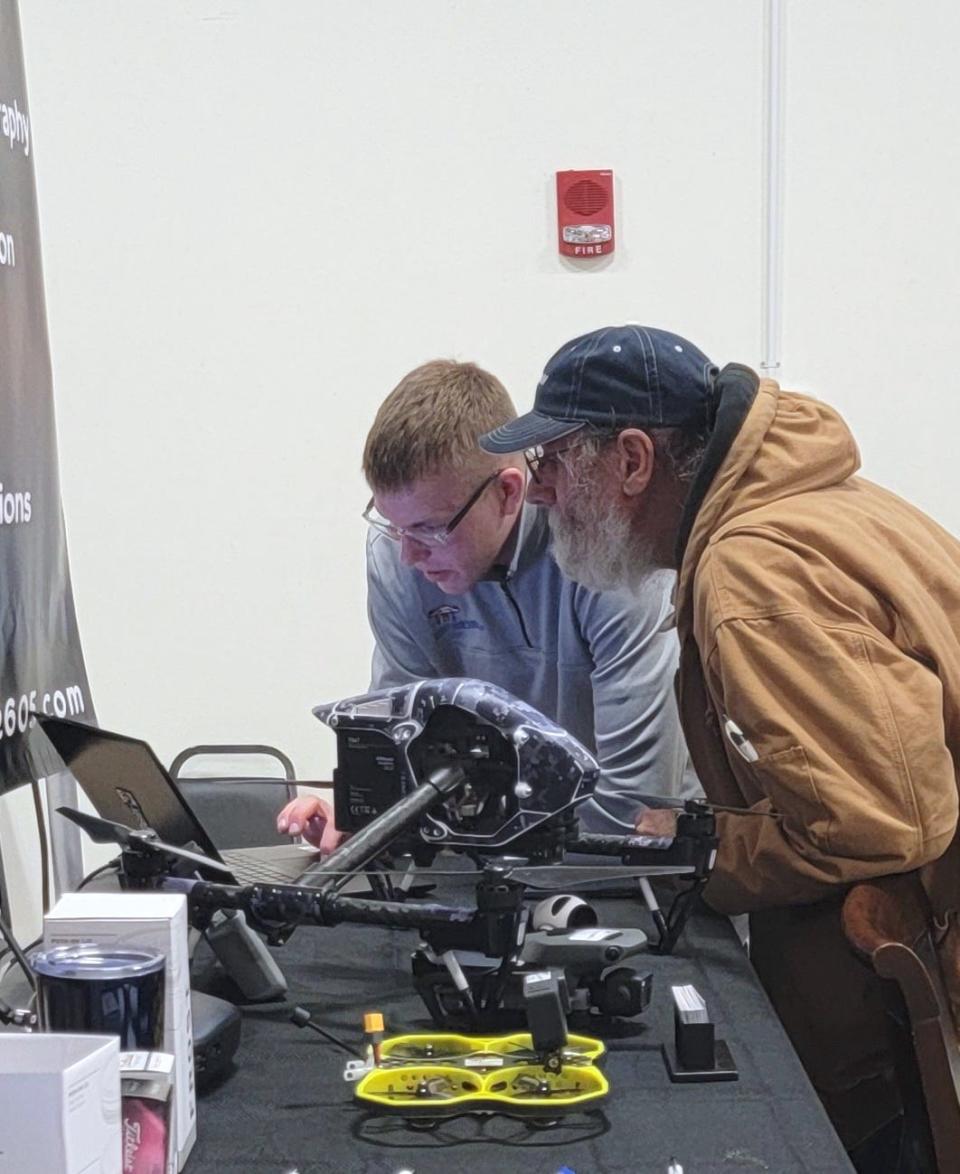 Nolan Hansen, left, owner of Elevate Drone Services, shows what his drones can do during the Winter Farm Show.