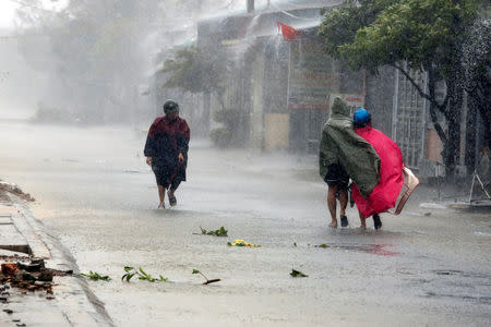 Residents walk in rain as Doksuri storm hits Ha Tinh province, Vietnam September 15, 2017. REUTERS/Kham