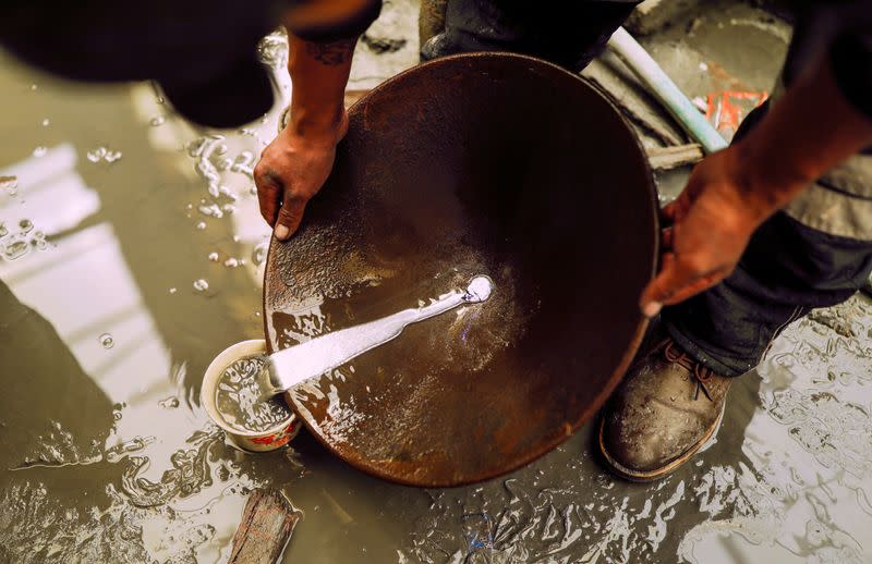 An artisanal gold miner uses a basin and mercury to pan for gold in La Rinconada, in the Andes