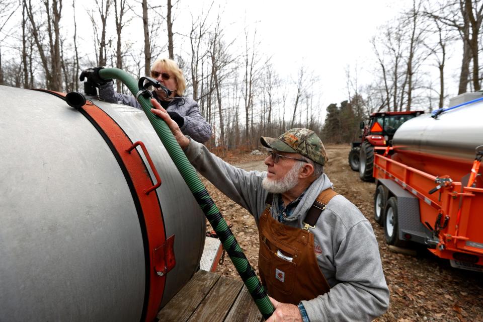 With the tank on the right already full of sap from their 200 acres of maple trees, Mary and Larry Haigh of Haigh's Sugar House Farm in Bellevue attach a hose to an empty tank and get it ready to collect more sap on Thursday, Feb. 22, 2024. Sap is 98% water and 2% sugar before it's boiled and evaporated to become maple syrup.