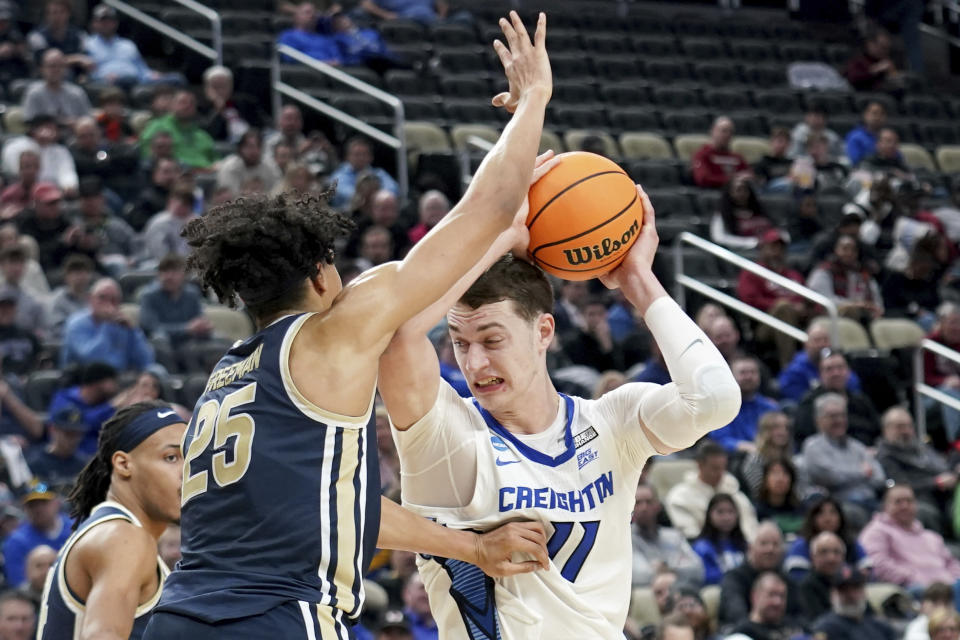 Creighton's Ryan Kalkbrenner (11) drives against Akron's Enrique Freeman (25) during the second half of a first-round college basketball game in the NCAA Tournament Thursday, March 21, 2024, in Pittsburgh. (AP Photo/Matt Freed)