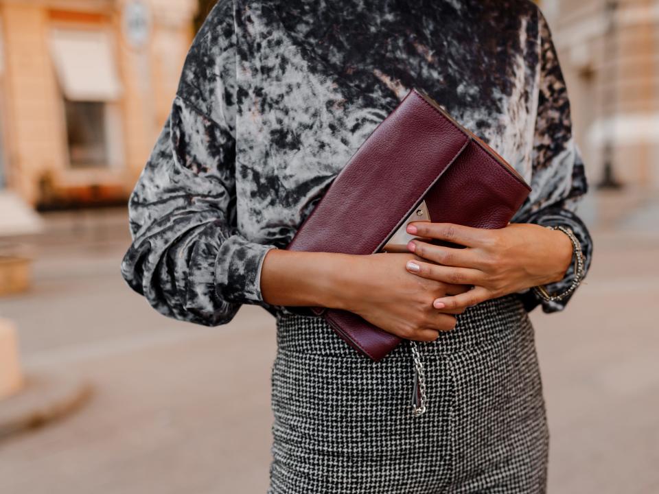 woman clutch purse patterned pants