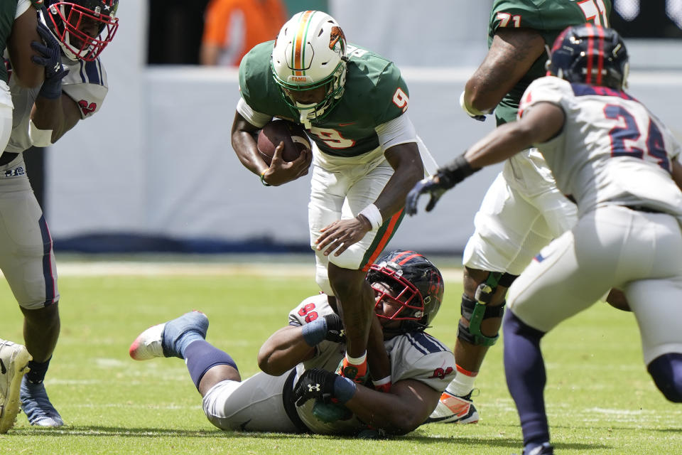 Florida A&M running back Kelvin Dean (9) is brought down by Jackson State defensive lineman Jeremiah Williams (99) during the first half of the Orange Blossom Classic NCAA college football game, Sunday, Sept. 3, 2023, in Miami Gardens, Fla. (AP Photo/Lynne Sladky)