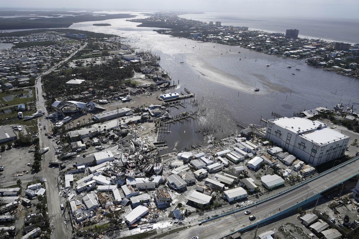 Damaged boats lie on the land and water in the aftermath of Hurricane Ian, Thursday, Sept. 29, 2022, in Fort Myers, Fla.