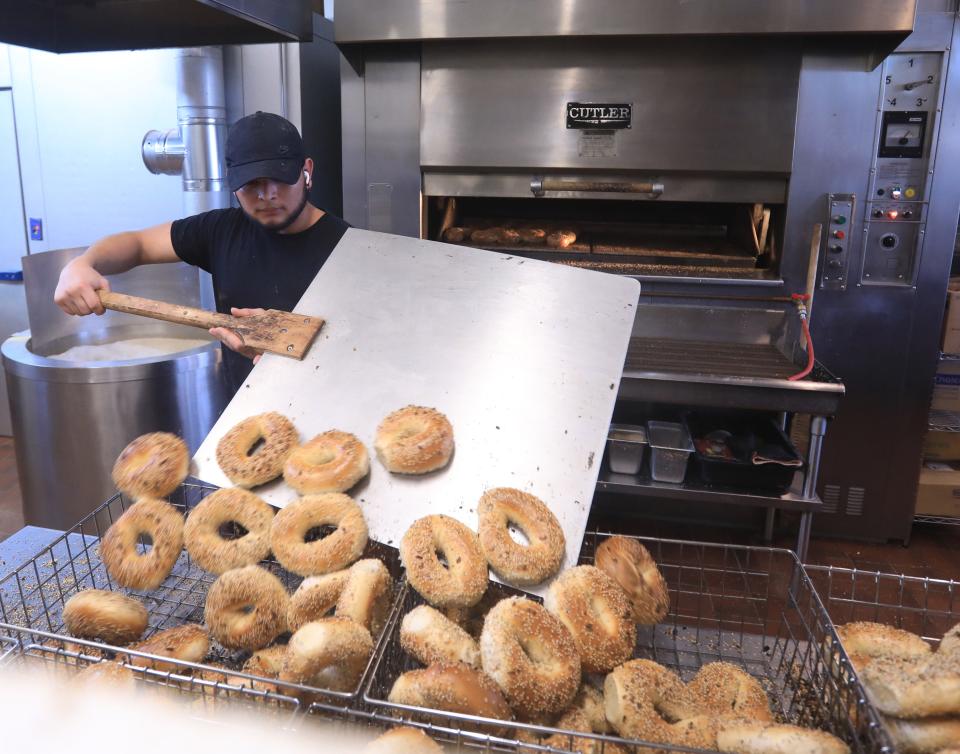 Eastdale Ave. Bagels baker, Cristobal Morataya, removes a batch of bagels from the oven on February 21, 2022.