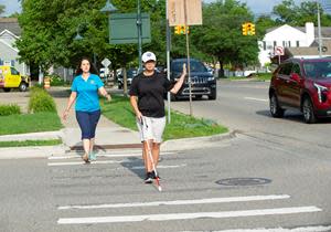 Leader Dogs for the Blind Client Brooke C. successfully completes a street crossing in downtown Rochester, Michigan under the watchful eye of LDB Orientation and Mobility Specialist Kristy Plesscher.