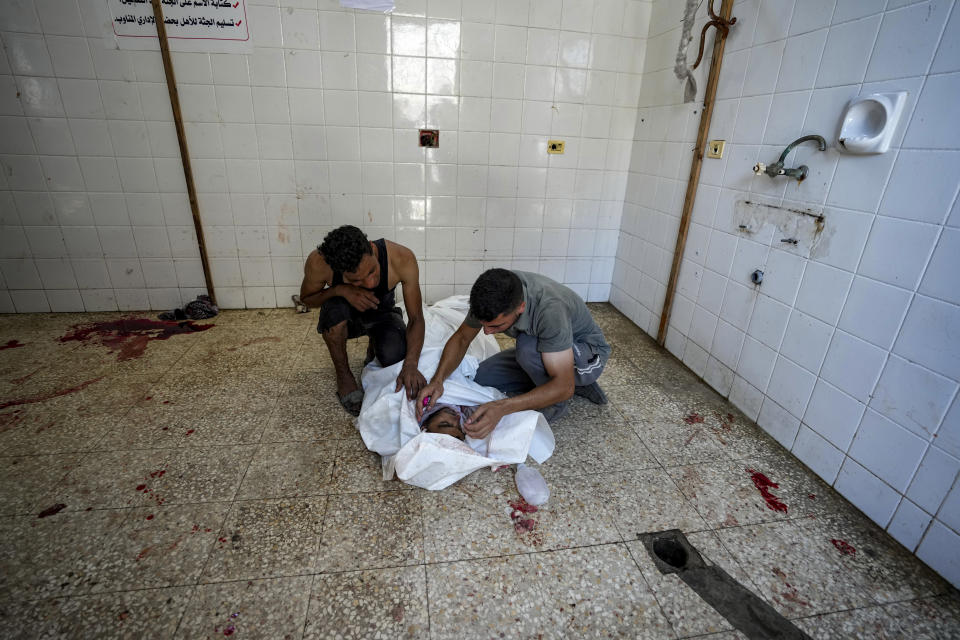 Palestinians mourn a relative killed in the Israeli bombardment of the Gaza Strip, at a hospital morgue in Deir al-Balah, Tuesday, July 9, 2024. (AP Photo/Abdel Kareem Hana)