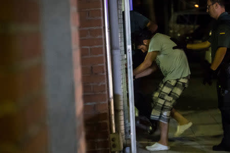 Spanish Civil Guards escort one of four men accused of involvement in an Islamist cell behind a van attack in Barcelona last week, in Tres Cantos, Spain, August 21, 2017. REUTERS/Juan Medina